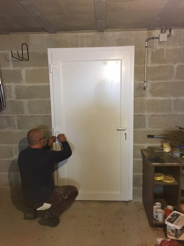 Installation d'une porte de service en PVC blanc sur mesure pleine